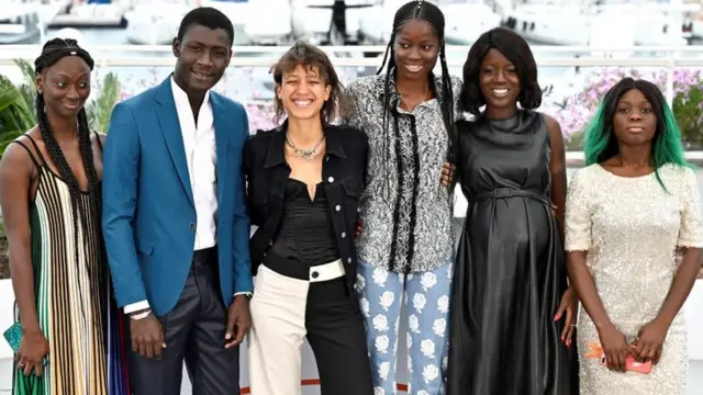 De gauche à droite, les acteurs sénégalais Mariama Gassama et Amadou Mbow, la réalisatrice Mati Diop, les actrices Mame Bineta Sané, Nicole Sougou et Aminata Kane, Sénégalaises aussi, lors de la présentation du film "Atlantique" à Cannes, le 17 mai 2019.