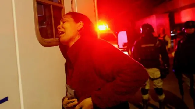 Viangly, a Venezuelan migrant, outside an ambulance that contains her injured husband