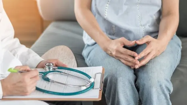 Mulher sentada conversando com médico