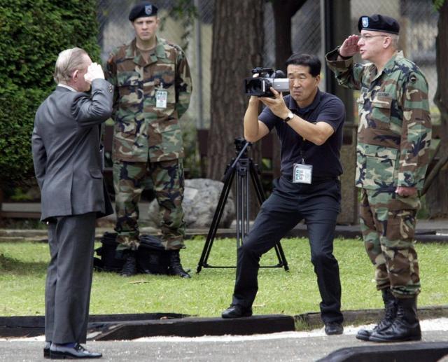 Charles Jenkins salutes Lieutenant Colonel Paul Nigara, as he is return to US military control at Camp Zama in Japan, on 11 September 2004.
