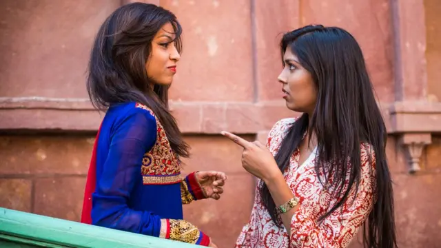 Two young women exchange opposing opinions.