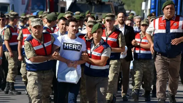 گوکان گوچلو، یک سرباز پیشین ارتش که متهم به شرکت در کودتای نافرجام سال پیش شده، در جلسه دادگاهش با تی‌شرتی شرکت کرد که روی آن کلمه قهرمان دیده می‌شد.