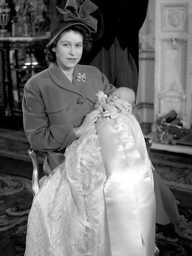 Princess Elizabeth holding her infant son, Prince Charles, after his christening ceremony at Buckingham Palace