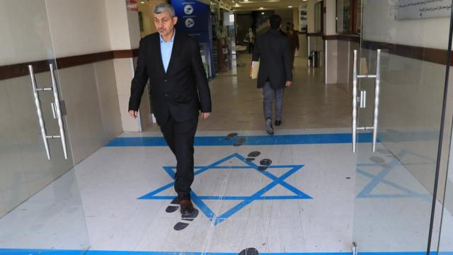 رجل يمشي فوق رسم للعلم الإسرائيلي