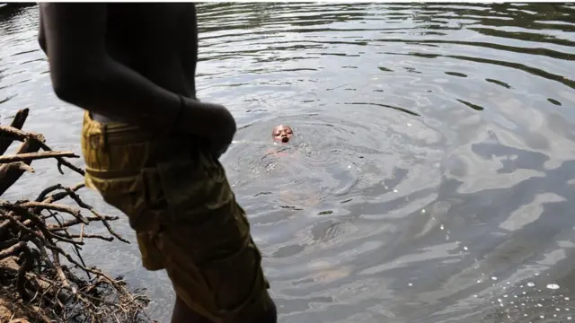 person dey piss for water wey pickin dey swim