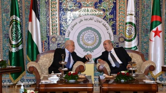 الرئيس الجزائري عبد المجيد تبون (يمين) يلتقي الرئيس الفلسطيني محمود عباس (يسار) في مطار هواري بومدين الدولي بالجزائر العاصمة