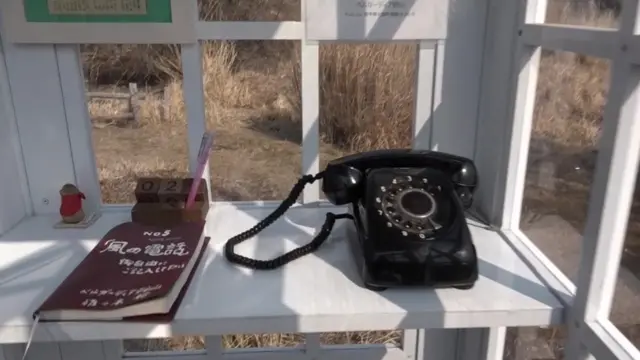 El teléfono negro dentro de la cabina.