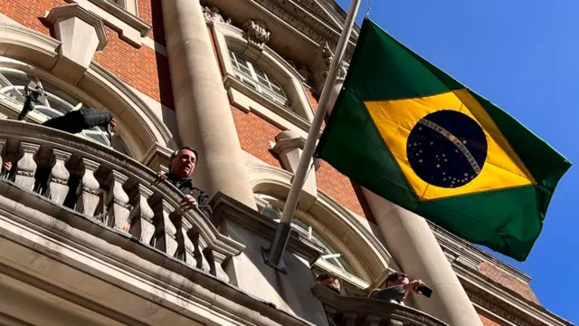 Com bandeira a meio mastro, Bolsonaro discursa a apoiadores na sacada da residência do embaixadorLondres