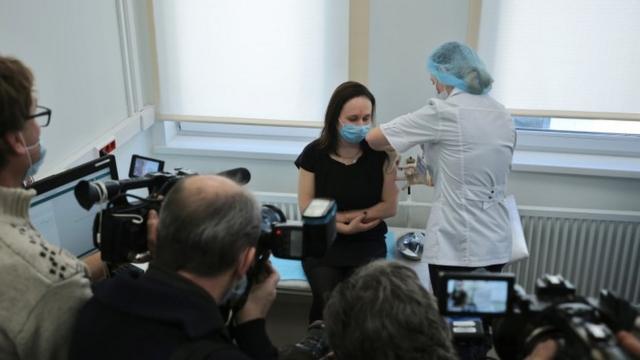 Mujer vacunándose frente a periodistas en Moscú.