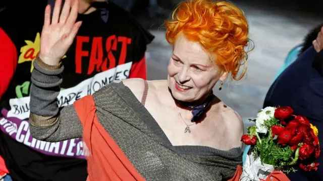 Vivienne Westwood acenando e sorrindo entre outras pessoas