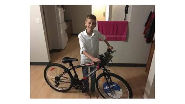 支援団体のママンさんからもらった自転車を見せるエマド君