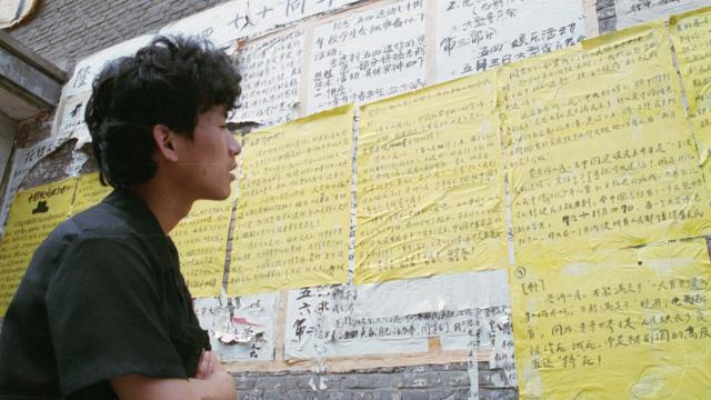 1989年，北京一大学生在查看公告栏关于中国民主设想的文章。