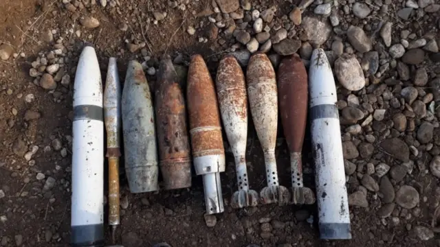 Лежащие рядом на земле снаряды. Некоторые очень ржавые, другие выглядят новее