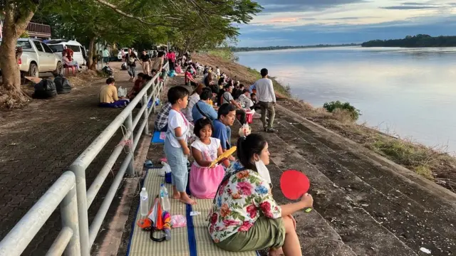 คนนั่งริมแม่น้ำโขง