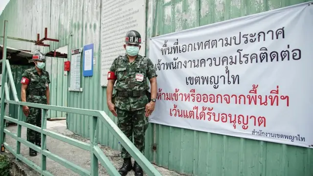 ทหารยืนเฝ้าแคม์ปคนงานก่อสร้าง