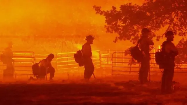 Firefighters look on as the Oak Fire burns in Darrah in Mariposa County, California, U.S. July 22, 2022.