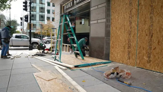 рабочие заколачивают витрины