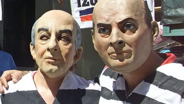 Dos manifestantes en plena crisis de 2001 en Argentina vestidos de presidiarios con máscaras del entonces presidente Fernando de la Rúa y su ministro de economía, Fernando Cavallo.