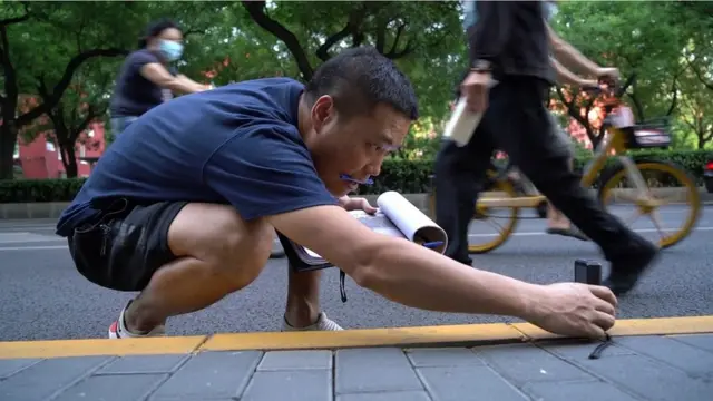 రేంజ్ ఫైండర్‌తో రోడ్డు పొడవు కొలుస్తున్న డెంగ్