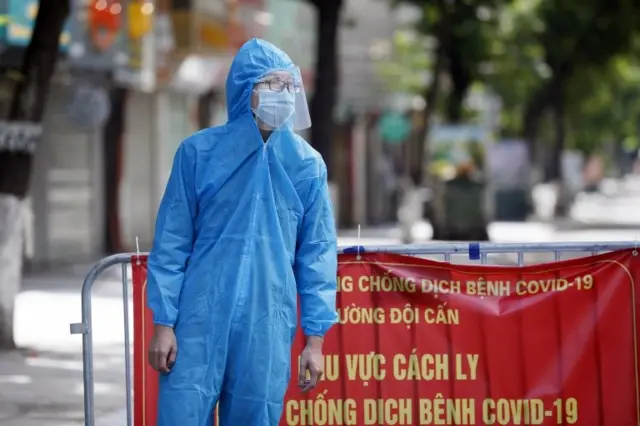 Một người đàn ông mặc thiết bị bảo vệ cá nhân trong khu vực cách ly ở Hà Nội, ngày 13 tháng 8 năm 2021