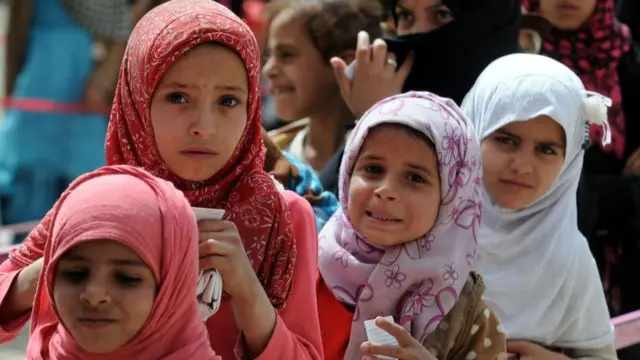 نساء وفتيات يمنيات تضررن بالحرب يقفن في طابور لاستلام المساعدات من جمعية خيرية