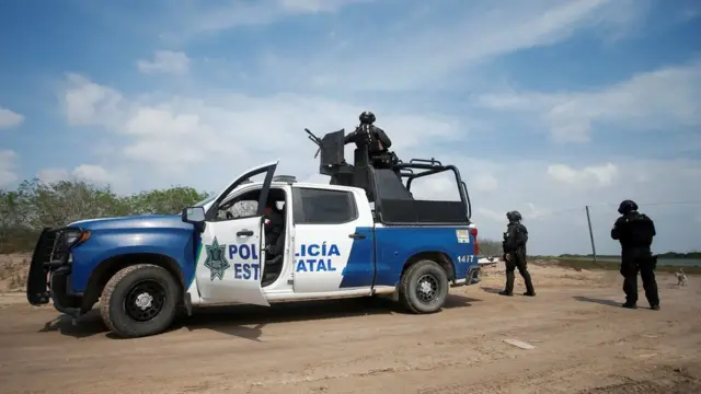 墨西哥塔毛利帕斯州馬塔莫羅斯市州警警員在發現兩名美國籍死者現場持槍把守（7/3/2023）
