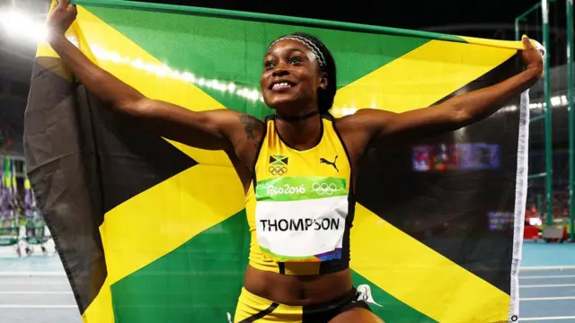 Thompson con la bandera de Jamaica