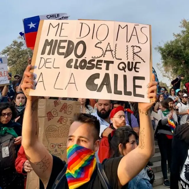 Un hombre sostiene un cartel