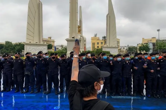 A pro-democracy protester flashes a three-finger salute during a protest against government and monarchy near the Democracy Monument in Bangkok, Thailand October 13, 2020.
