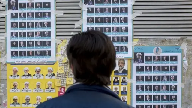 ناخب أمام لوحات المرشحين