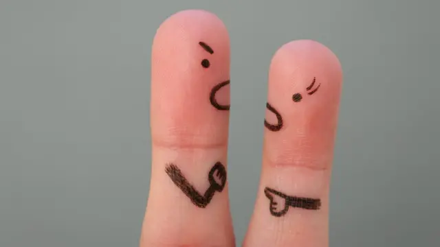 Dedos pintados que representan a un padre y a su hija teniendo una discusión