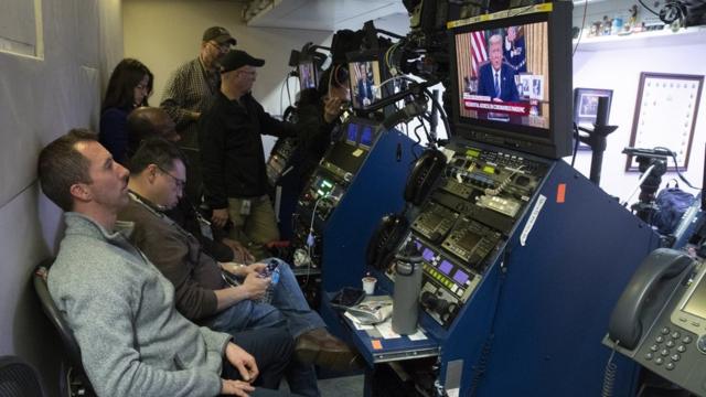 Operadores de câmara observam Trump fazendo discurso na tela