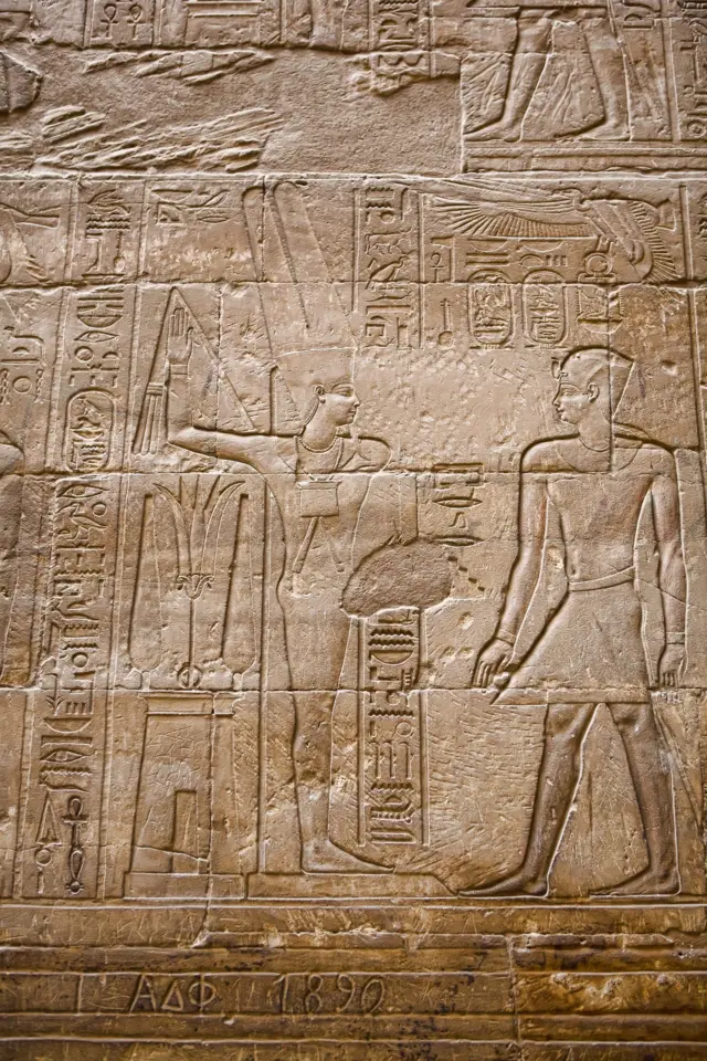 نحت بارز يصوّر الإسكندر الأكبر مرتديًا زيّ الفرعون، وفي هذه المناظر يتلقى تاجي مصر العليا والسفلى من الإله مين في معبد الأقصر