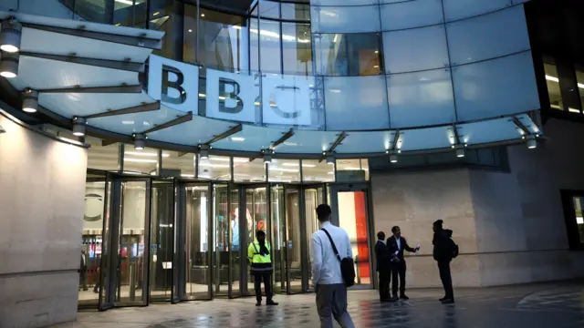 Ludzie spacerują przed BBC Broadcasting House po rezygnacji dyrektora generalnego BBC Tima Davie i dyrektor generalnej BBC News Deborah Turnness 