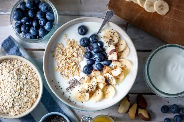 tigela de iogurte com aveia, mirtilo, banana e castanhas