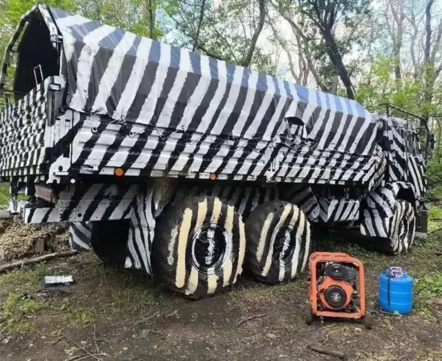 Вантажівка КамАЗ розмальована чорно-білими смугами