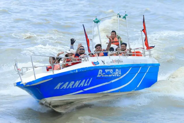 मोटरबोटमा रमाउँदै गरेका मानिसहरू