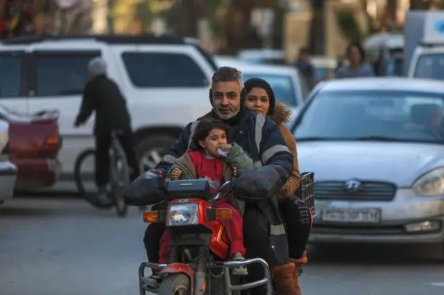عائلة من ثلاثة أفراد تركب دراجة نارية في مدينة جرمانا ذات الأغلبية الدرزية بريف دمشق، في 2 مارس/آذار 2025.