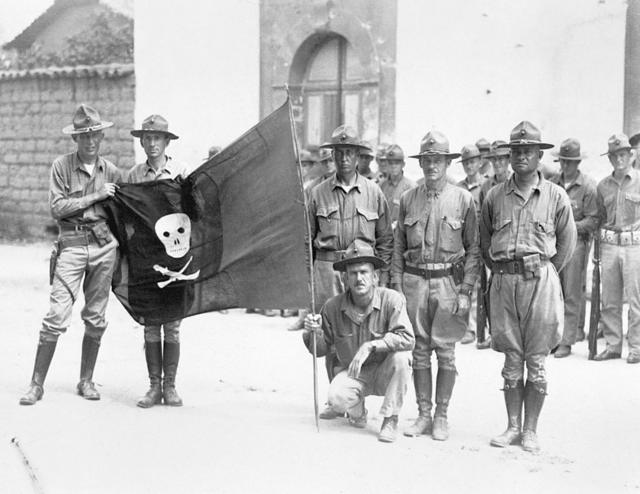 Soldados estadounidenses exhiben una bandera capturada a la guerrilla de Sandino en 1932