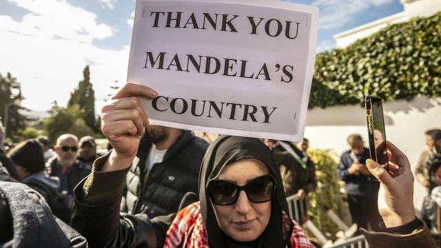 Mujer con un cartel que dice "Gracias, país de Mandela"