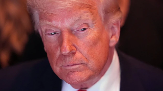 Trump düşünceli şekilde aşağıya bakıyor. 