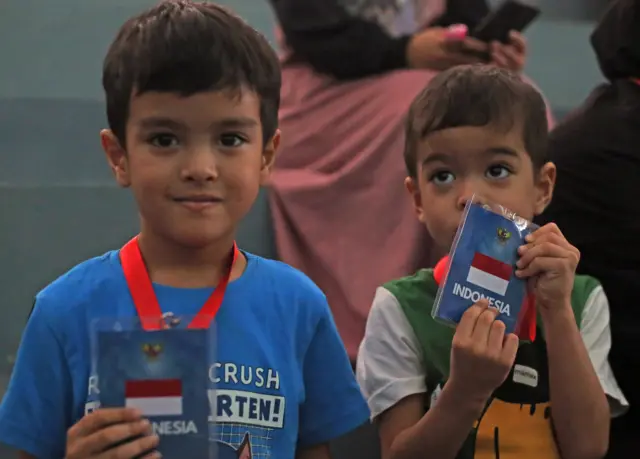 Dua anak Rina Mardiani yang kembali dari Lebaon memegang kartu identitas mereka setibanya di Terminal 3 Bandara Soekarno Hatta, Tangerang, Banten, Senin (07/10).