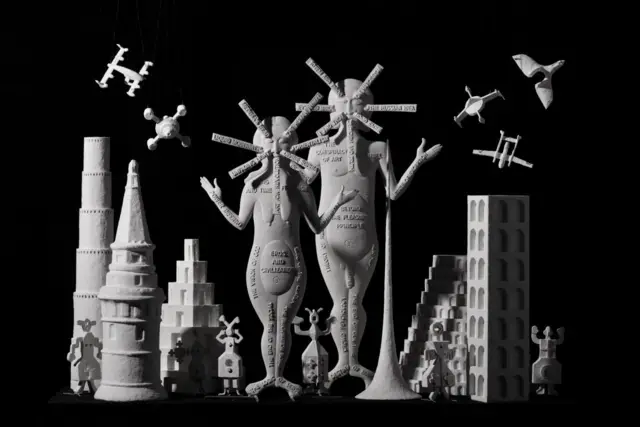 Инсталляция из условных человеческих фигур, зданий и беспилотников