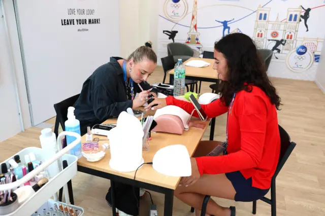 An athlete gets her nails done at the nail bar inside the Olympic Village beauty salon on 24 July 2024.