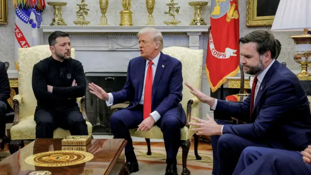 El presidente de Ucrania, Volodymyr Zelensky (izq.) con las manos cruzadas, reunido en la Oficina Oval con el presidente de EE.UU., Donald Trump (centro) y su vicepresidente JD Vance (der.) Los tres están sentados y Trump y Vance gesticulan con la mano en desagrado hacia Zelensky