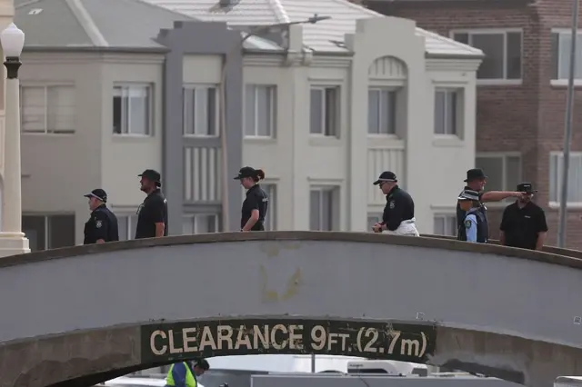 एउटा पुलमाथि प्रहरीहरू - बोन्डी बीचमा गोली प्रहार भएको घटनास्थलको निरीक्षण गर्दै सुरक्षाकर्मीहरू