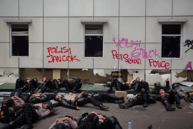 Sejumlah polisi beristirahat pascaaksi unjuk rasa di Polda D.I Yogyakarta, Sabtu (30/8/2025). Hingga saat ini, Polda DIY masih melakukan inventarisasi kerusakan dampak unjuk rasa oleh mahasiswa serta berbagai elemen masyarakat yang mengecam tindakan kekerasan polisi kepada masyarakat sipil dan menuntut dibatalkanya kenaikan tunjangan anggota DPR pada Jumat (29/8/2025). 