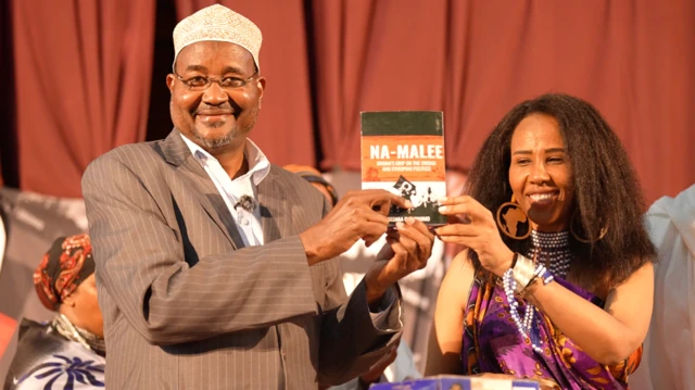 Waggaa 15f Kaawuntii Taanaa Riiver keessatti naannawa Burraa bakka bu'uun Paarlaamaa Keeniyaa keessa kan turan Kabajamoo Alii Waariyoo (bitaa) fi Seenaa Jimjimoo, eebba kitaaba 'Na Malee' irratti