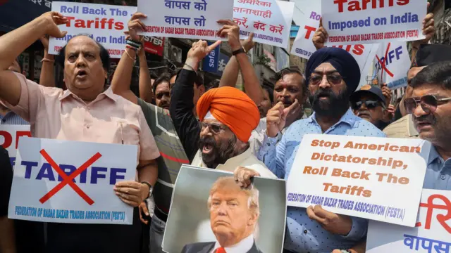 Протестувальники з портретом Трампа та плакатами проти його тарифів