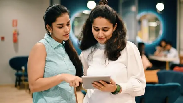 (सांकेतिक तस्वीर) दो लड़कियां टैबलेट में कुछ देख रही हैं.